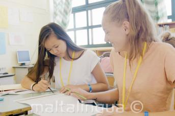 2 lányok közösen dolgozik egy angol nyelvi feladaton azt osztályteremben