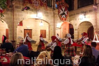 Hagyományos máltai táncosok előadása egy étteremben