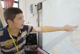 Tanuló egy térképre mutat az osztályteremben