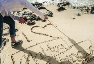 Egy diák a homokba rajzolja: Én 'szív' Maltalingua
